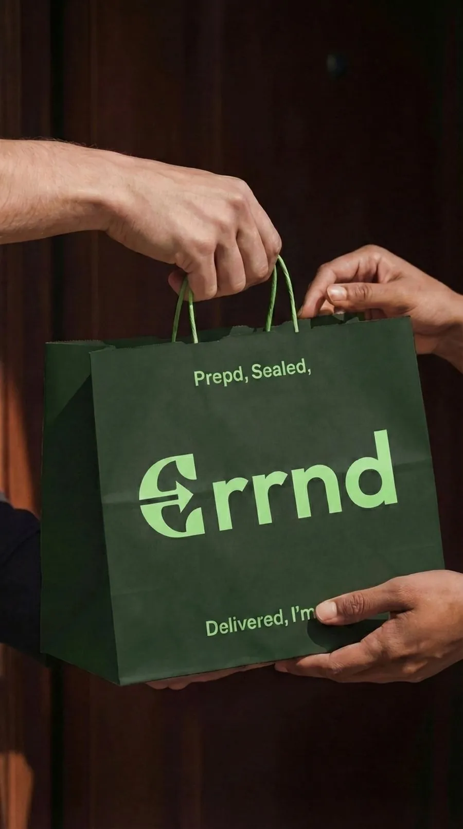 A courier handing an Errnd bag to a customer